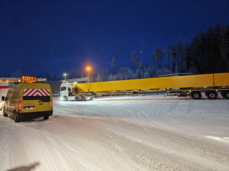 Pitkä kuljetus teräspalkeilla ja saattoautolla